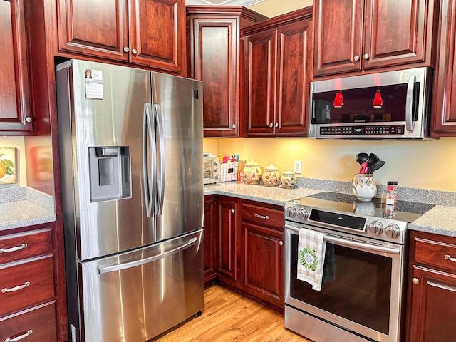 kitchen with reddish brown cabinets and stainless steel appliances