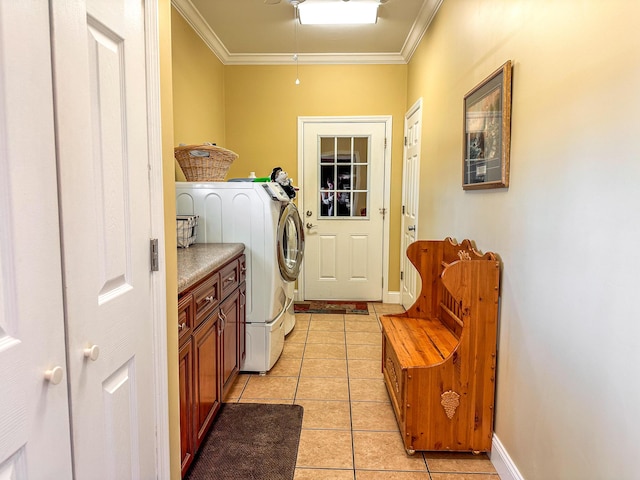 clothes washing area with washer and clothes dryer, light tile patterned floors, cabinet space, and ornamental molding