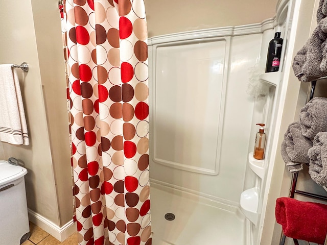 full bathroom featuring baseboards, toilet, a shower stall, and tile patterned flooring