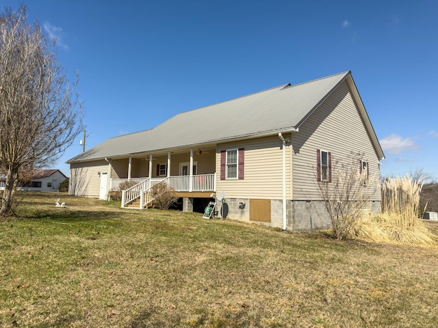 back of property with a porch, metal roof, a yard, and a ceiling fan