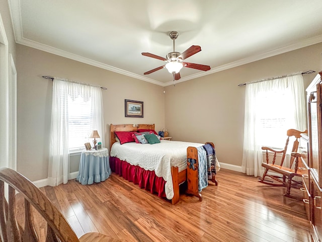 bedroom featuring crown molding, light wood-style flooring, and baseboards