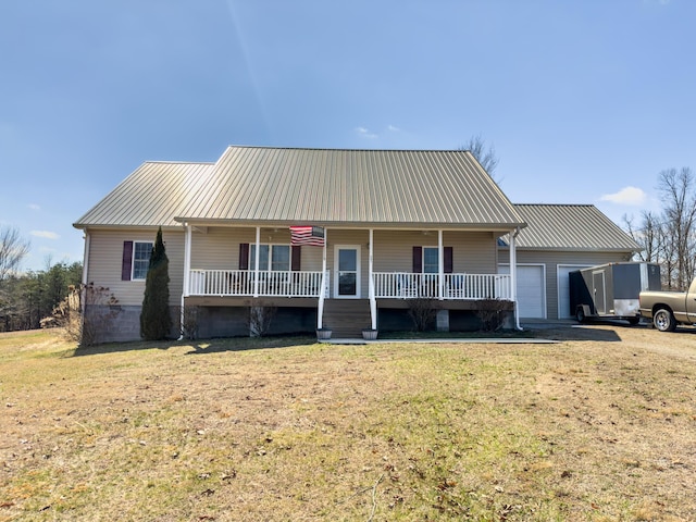 view of front of home with metal roof, a front lawn, a porch, and an attached garage