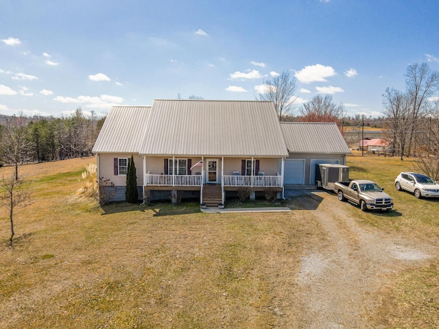 view of front facade featuring a front yard, a garage, driveway, and metal roof