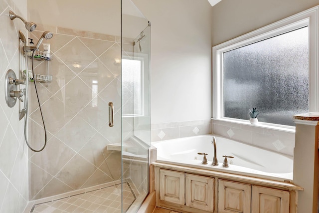 bathroom with a bath, a healthy amount of sunlight, and a stall shower