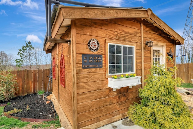 view of outbuilding featuring fence