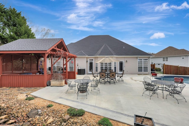 back of property with a gazebo, outdoor dining space, a patio, and fence