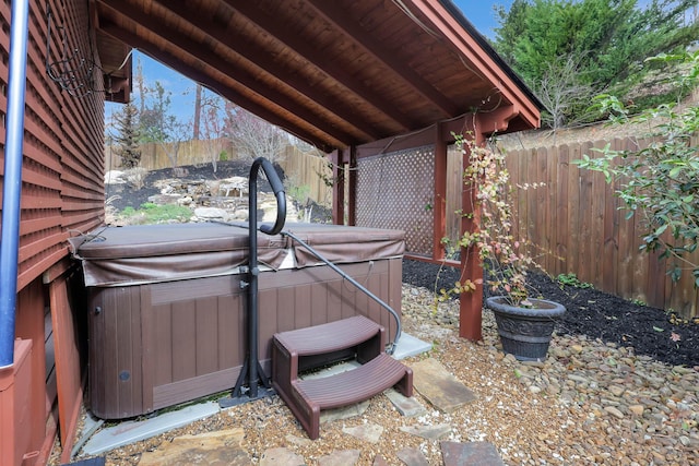 exterior space featuring a jacuzzi and a fenced backyard