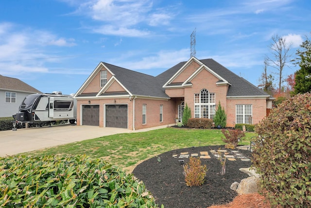 view of front facade with a front lawn, brick siding, driveway, and roof with shingles