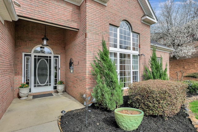 doorway to property featuring brick siding