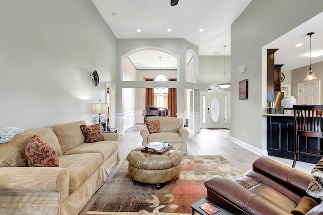 living room with recessed lighting, a high ceiling, and light wood finished floors