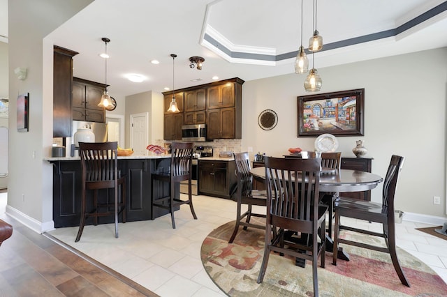 dining area featuring a raised ceiling, light tile patterned flooring, recessed lighting, and baseboards