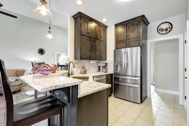 kitchen with tasteful backsplash, dark brown cabinetry, a peninsula, stainless steel refrigerator with ice dispenser, and a sink