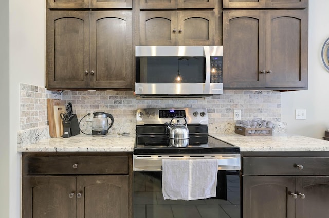 kitchen with dark brown cabinets, tasteful backsplash, and stainless steel appliances