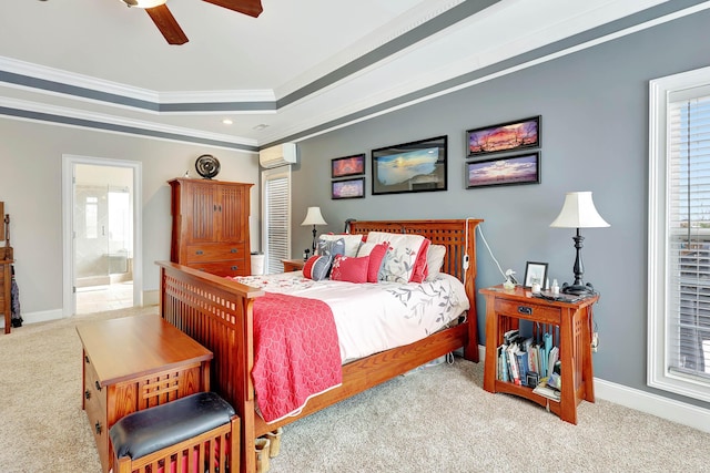 bedroom with multiple windows, an AC wall unit, a tray ceiling, and carpet floors