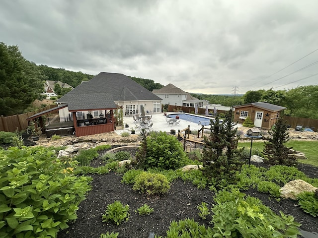 back of property with a fenced backyard, a fenced in pool, an outdoor structure, and a deck