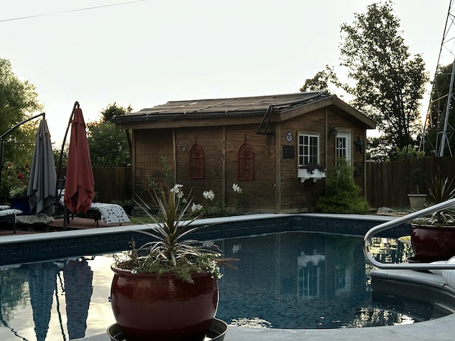 view of pool with an outbuilding, a fenced in pool, and fence