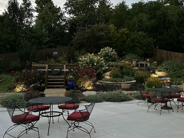 view of patio with outdoor dining area, stairway, a deck, and fence