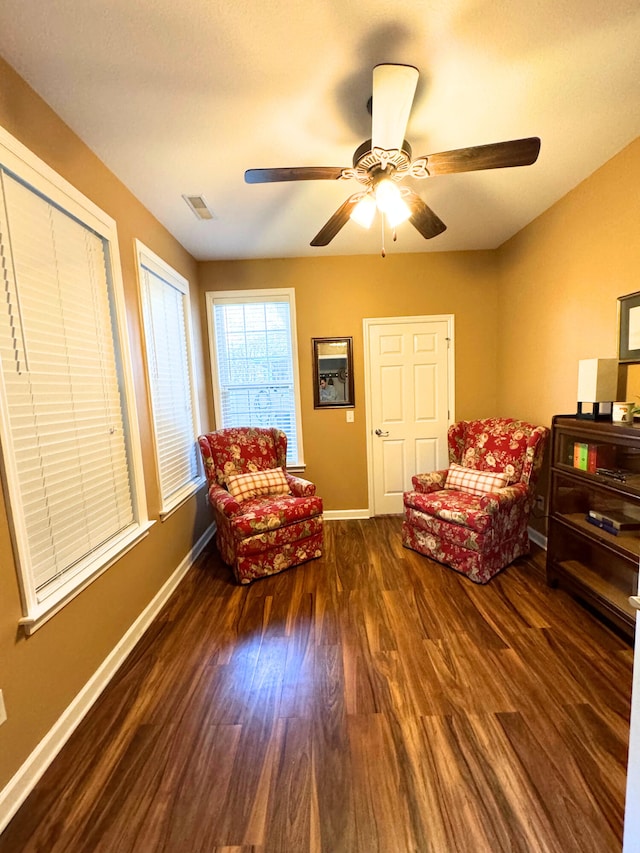 sitting room featuring ceiling fan, visible vents, baseboards, and wood finished floors