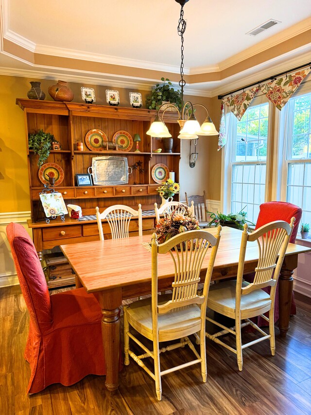 dining room featuring visible vents, crown molding, and wood finished floors