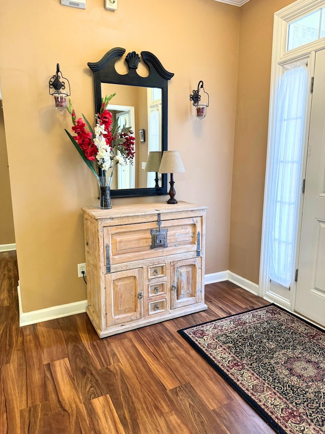 foyer with dark wood-type flooring and baseboards