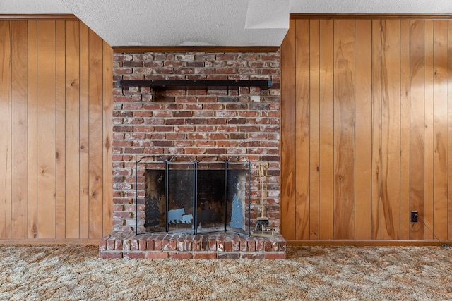 details featuring carpet floors, wooden walls, a brick fireplace, and a textured ceiling