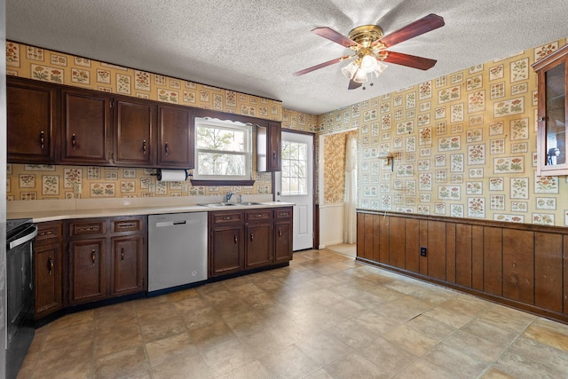 kitchen with wallpapered walls, a wainscoted wall, dishwasher, electric range, and a textured ceiling