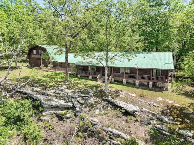 rear view of property featuring a porch and metal roof