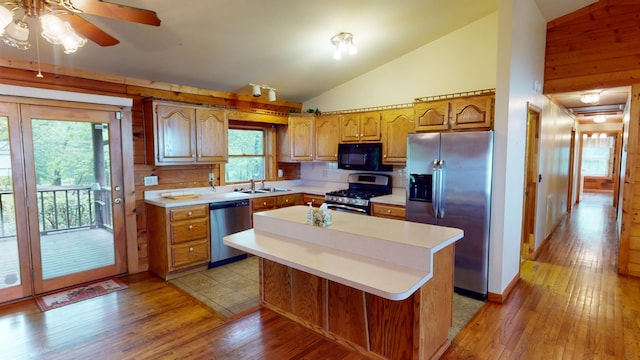 kitchen with light wood-style flooring, stainless steel appliances, light countertops, and a sink