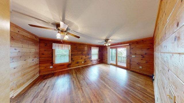 spare room with visible vents, wooden walls, and wood finished floors