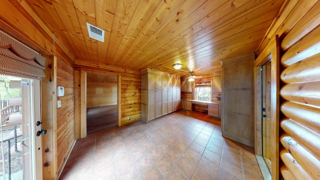 interior space featuring light tile patterned floors, visible vents, wood walls, and wooden ceiling