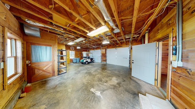 garage featuring wooden walls and a garage door opener