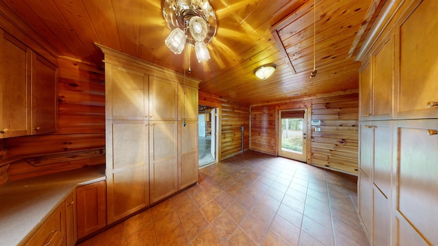 kitchen featuring wooden ceiling, light countertops, brown cabinets, and rustic walls