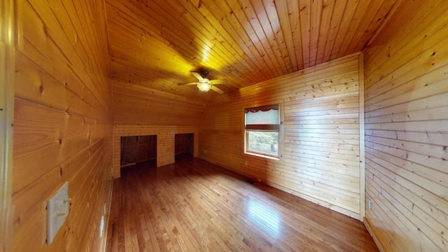 additional living space featuring ceiling fan, wood walls, vaulted ceiling, hardwood / wood-style floors, and wooden ceiling