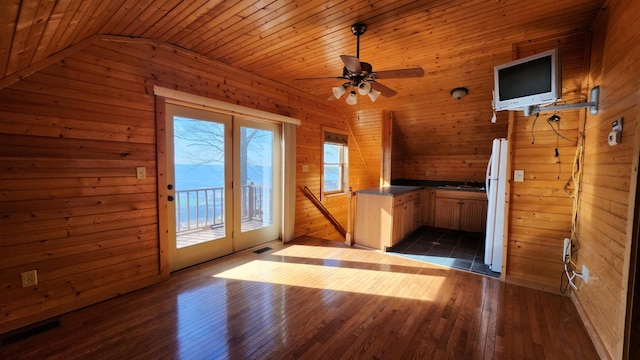 kitchen featuring visible vents, wood walls, freestanding refrigerator, and dark wood-style flooring