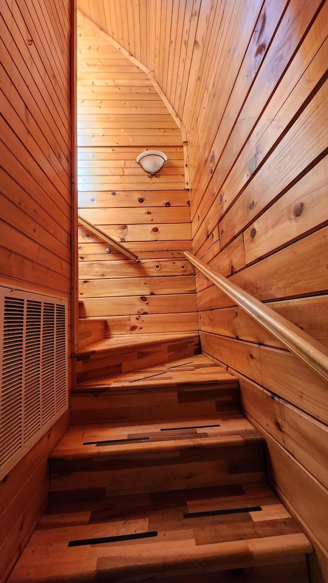 stairs featuring a sauna, visible vents, wood walls, and wood ceiling