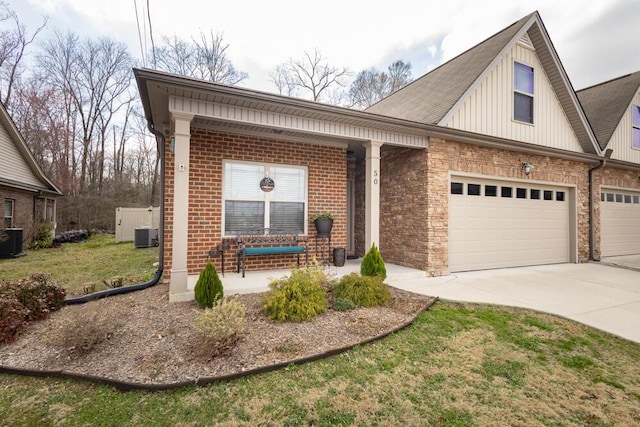 view of front of house featuring driveway, a porch, central AC, an attached garage, and brick siding