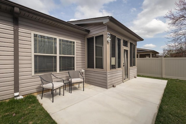 view of patio with a sunroom and fence