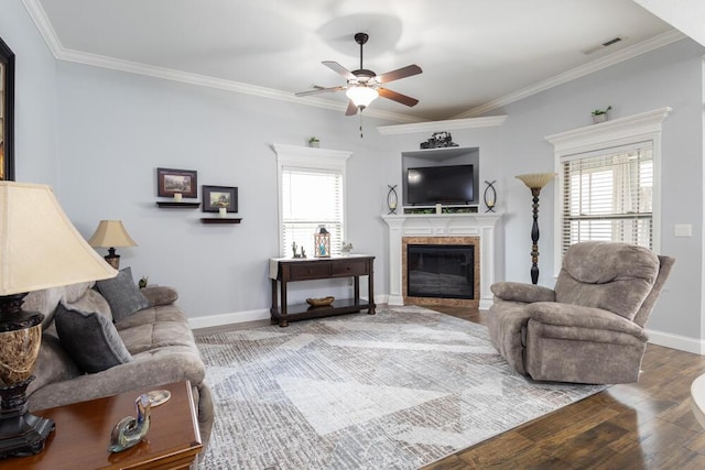 living room with visible vents, wood finished floors, a fireplace, and ornamental molding