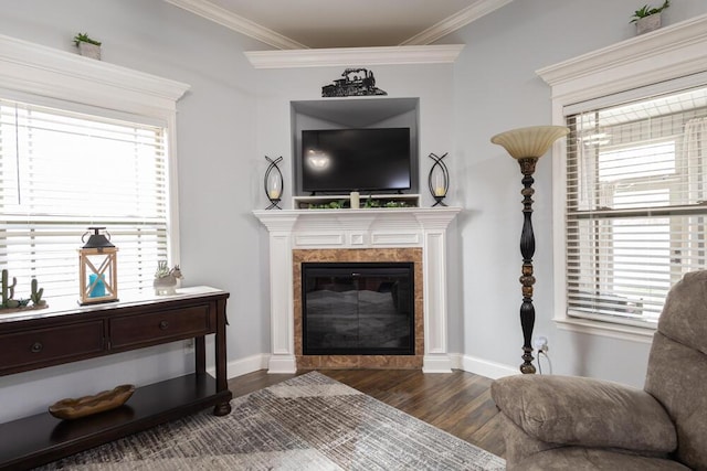 living room with a tiled fireplace, baseboards, crown molding, and dark wood-type flooring