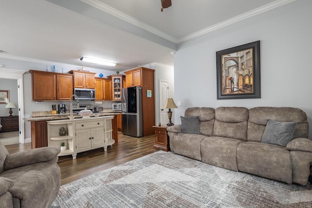 living room featuring dark wood finished floors, crown molding, and a ceiling fan