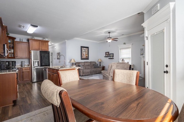 dining room featuring crown molding, dark wood-style flooring, and ceiling fan