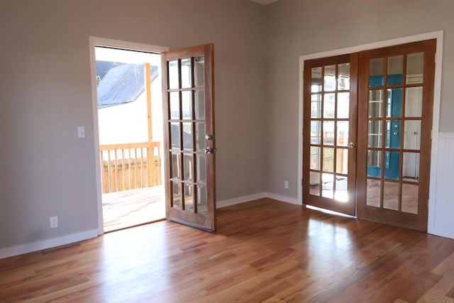 doorway featuring wood finished floors, french doors, and baseboards