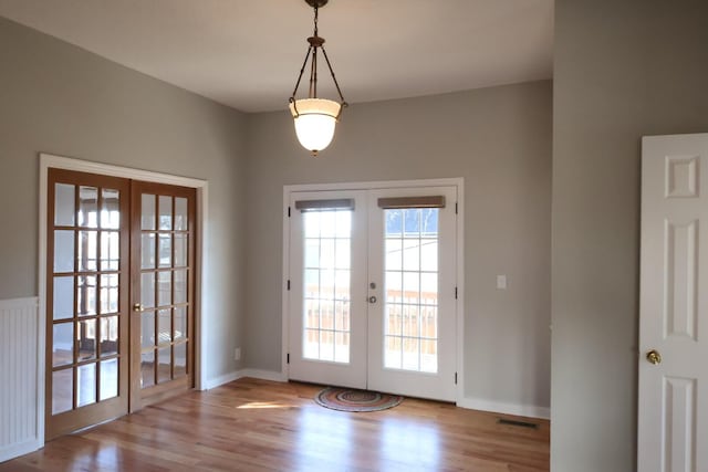 doorway to outside featuring wood finished floors, french doors, baseboards, and visible vents