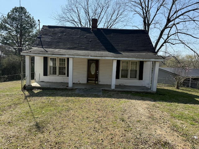 view of front of property featuring a chimney, a front lawn, and fence