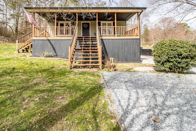 view of front of property featuring a ceiling fan, a front yard, and stairs