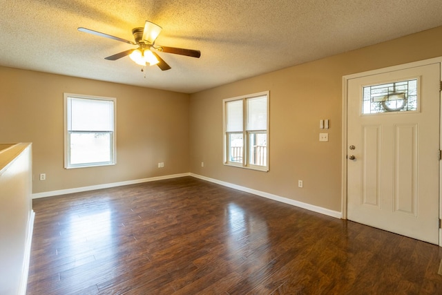 foyer entrance with a healthy amount of sunlight, dark wood-style floors, and a ceiling fan