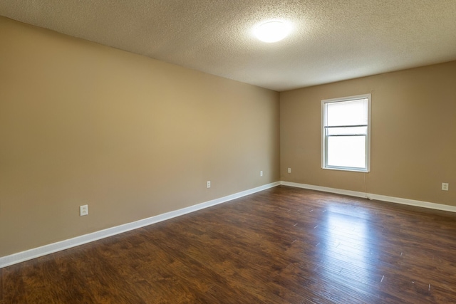 unfurnished room featuring dark wood-style floors, a textured ceiling, and baseboards