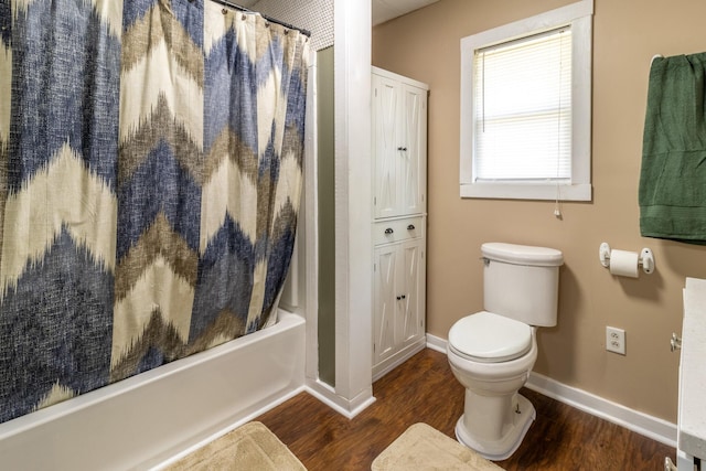 full bath with toilet, wood finished floors, baseboards, and shower / tub combo with curtain