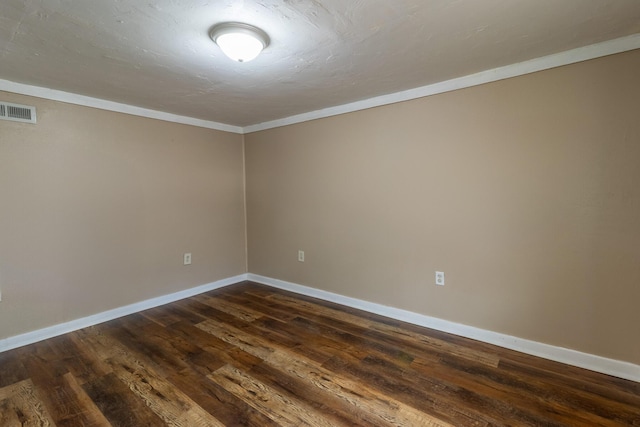 unfurnished room with dark wood-type flooring, baseboards, visible vents, and ornamental molding