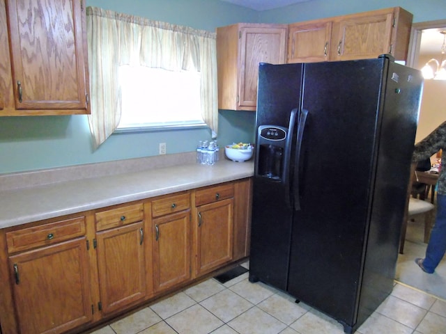 2813 Nile Rd, Chattanooga, TN 37421 - kitchen with light countertops, light tile patterned floors, brown cabinets, and black fridge with ice dispenser